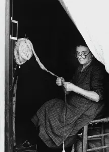 Frau beim Spinnen von Wolle