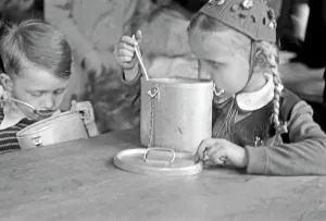 Ein Junge und ein Mädchen bei der Speisung durch die Canadian Lutheran World Relief in einer karitativen Einrichtung in Frankfurt an der Oder, Deutschland 1948.