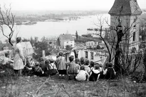 Kinder aus einem Lebuser Kindergarten wandern um die Kleinstadt mit der Evangelischen Stadtkirche im Hintergrund, Deutschland 1949.