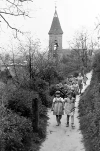 Kinder aus einem Lebuser Kindergarten wandern um die Kleinstadt mit der Evangelischen Stadtkirche im Hintergrund, Deutschland 1949.