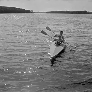 Ein Paar paddelt in einem Klepper Faltboot auf einem See, Deutschland 1930er Jahre.