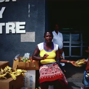 Straßenszene mit Verkäuferin am Obststand auf dem Markt in Bridgetown, Barbados, um 1985