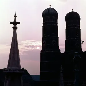 München Blick westlich über das Neue Rathaus am Marienplatz auf die Türme der Münchner Frauenkirche im Gegenlicht der Abendsonne