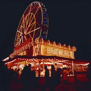 Ein Bratwurststand vor dem Riesenrad auf dem Münchner Oktoberfest in Bayern.