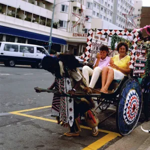 Touristen in einem Rikscha an der Marine Parade in Durban, Südafrika.