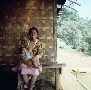 Eine indonesische Mutter beim Stillen ihres Babys auf Java, Indonesien in den 1980er Jahren.