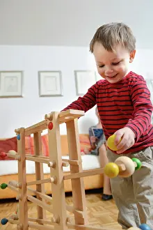 Family Leisure Time Activities Drucke: Boy playing skill game, smiling