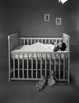 Drucke von Junge schläft im Kinderbett Mai Drucke: Junges Kind schläft in Bettchen.