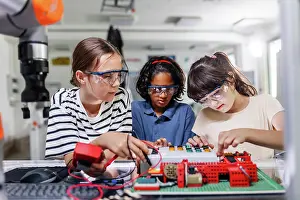 Drucke von Klassenkameraden arbeiten zusammen an einem Schaltkreis, bauen Roboter in dem Nachmittagsrobotikclub. Kinder lernen Robotik in der Grundschule Juni Drucke: Klassenkameraden arbeiten zusammen an einem Schaltkreisplatine.