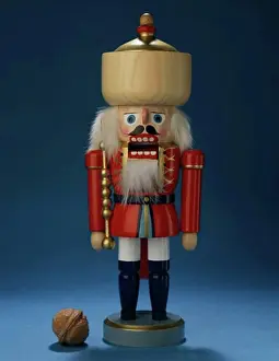Christmas Celebration Decorations Drucke: Close-up of a nutcracker with a walnut beside it