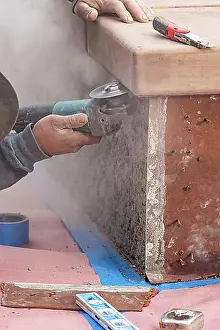 Construction Manpower Drucke: Construction worker using grinder at construction site