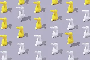 Drucke von Kreatives Muster mit gelben und weißen Kunststoff-Hase auf grauem Hintergrund April Drucke: Kreatives Muster mit gelben und weißen Kunststoff-Hase auf grauem Hintergrund.