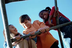 Childhood Friendship Drucke: Low angle view of three children playing on a monkey bars