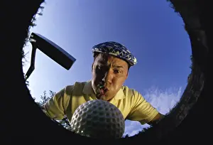 2001 Drucke: Blick von unten auf einen Golfball, der in ein Becken fällt.