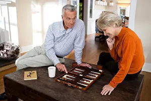 Drucke von Erfahrtes Ehepaar spielt Backgammon Juni Drucke: Erbauungsvolle Paar beim Backgammon spielen.