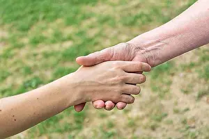 Handshake Concept Drucke: Old and young hands doing handshake
