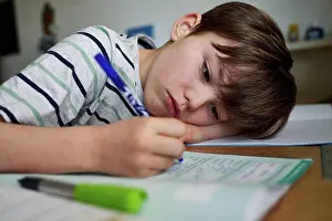 Bilder Datiert 30. April 2020: Porträt eines Jungen beim Hausaufgaben machen.