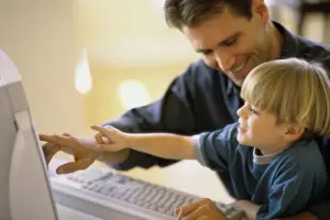 2002 Drucke: Seitenansicht eines Vaters und seines Sohnes, der einen Computer nutzt.