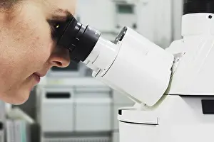 Scientific Experiment Drucke: Scientist looking through microscope