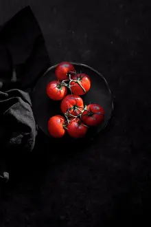 2018 Drucke: Tomaten auf schwarzem Hintergrund.
