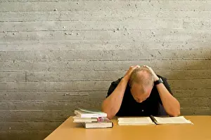 College Student Studying Drucke: Young man reading and studying in a library