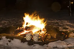 Deserted Snowy Landscape Drucke: 2 cups standing in front of a campfire