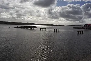 Deserted Waterfront Structures Drucke: Abandoned and half-destroyed pier structures under a cloudy sky