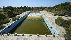 Drucke von Verlassenes Schwimmbad mit algenverseuchtem Wasser, Graffiti und Betonwänden, umgeben von Bäumen, Verlorenes Ort, faulendes Schwimmbad, Afandou, Rhodos, Dodekaneser Inseln Malerei Drucke: Verlassenes Schwimmbad mit algenverseuchtem Wasser.