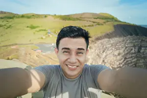 Drucke von Abenteuerlicher Mann nimmt ein Selfie an einem Aussichtspunkt. Nahansicht von einer Person, die ein Abenteuer-Selfie macht, Tourist nimmt ein Selfie an einem Aussichtspunkt Masaya Drucke: Abenteuerlicher Mann nimmt sich selbst bei einem Aussichtspunkt ab.
