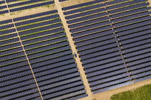 Alternative Energy Source Europe Drucke: Aerial solar panel fields with a small car on a dirt path