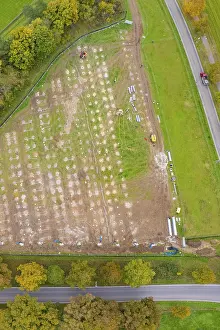 German Countryside Aerial View Drucke: Aerial view of a large rectangular field with construction activities surrounded by autumn trees