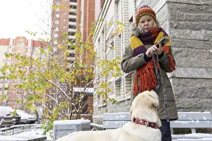 Purebred Dog Head Shot Drucke: Affection Moment. Outdoor winter scene where woman shares tender moment with pet dog surrounded by snow and bare trees