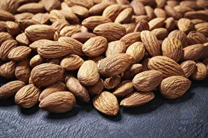 Black Background Photography Drucke: Almond nuts on black table, selective focus