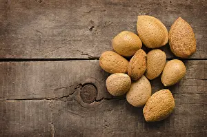 Empty Wooden Table Scene Drucke: Almonds on a rustic wooden table with space for text