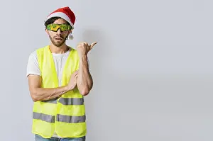 New Year Festival Image Drucke: Amazed builder engineer in christmas hat pointing a copy space