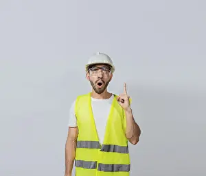 Construction Worker Pointing Drucke: Amazed engineer man pointing up