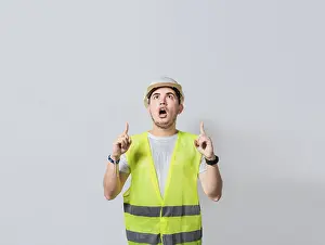 Construction Worker Pointing Drucke: Amazed engineer pointing at an advertisement