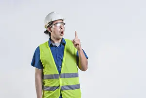 Young Engineer Drucke: Amazed engineer pointing up isolated