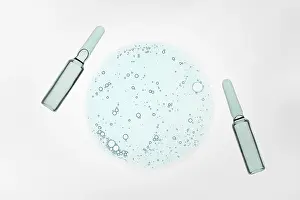 Scientific Laboratory Equipment Drucke: Two ampoules flank a circular pattern of blue liquid bubbles on a white background