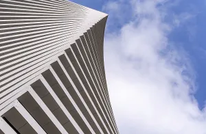Modern Building Design Drucke: Angular view of a modern building's facade with sleek lines against a bright sky