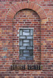 Abandoned Brick Architecture Drucke: Arch in a wall made from red bricks with a small glass element