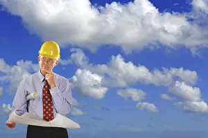 Residential Building Plans Drucke: Architect with construction plan and safety helmet visits building projects