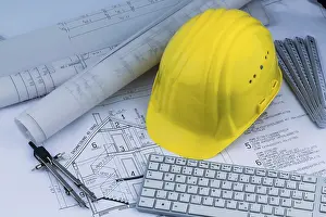 Construction Plan Drucke: An architect's construction plan with a builder's helmet
