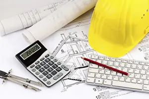 Architect Construction Plan Drucke: An architect's construction plan with a builder's helmet