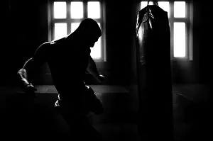 Kickboxing Athlete Drucke: Athlete hits the bag. Dramatic light
