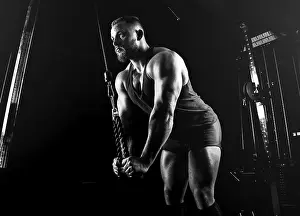 Male Athlete Training Drucke: The athlete performs an exercise on the triceps on a special device