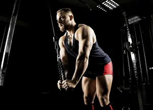 Health Conscious Athlete Drucke: The athlete performs an exercise on the triceps on a special device