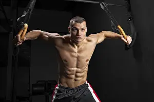 Fitness Concept Drucke: The athlete pulls himself up on the gymnastic rings
