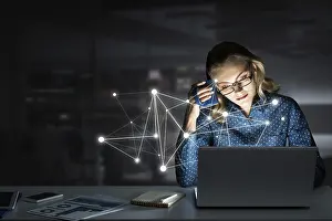 Gemischte Medien Drucke: Attraktive blonde mit Brille in dunklem Büro am Laptop arbeitet.