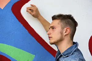 Urbane Kunst Drucke: Attraktiver junger blondner Mann gegen bunte Graffiti-Wand.